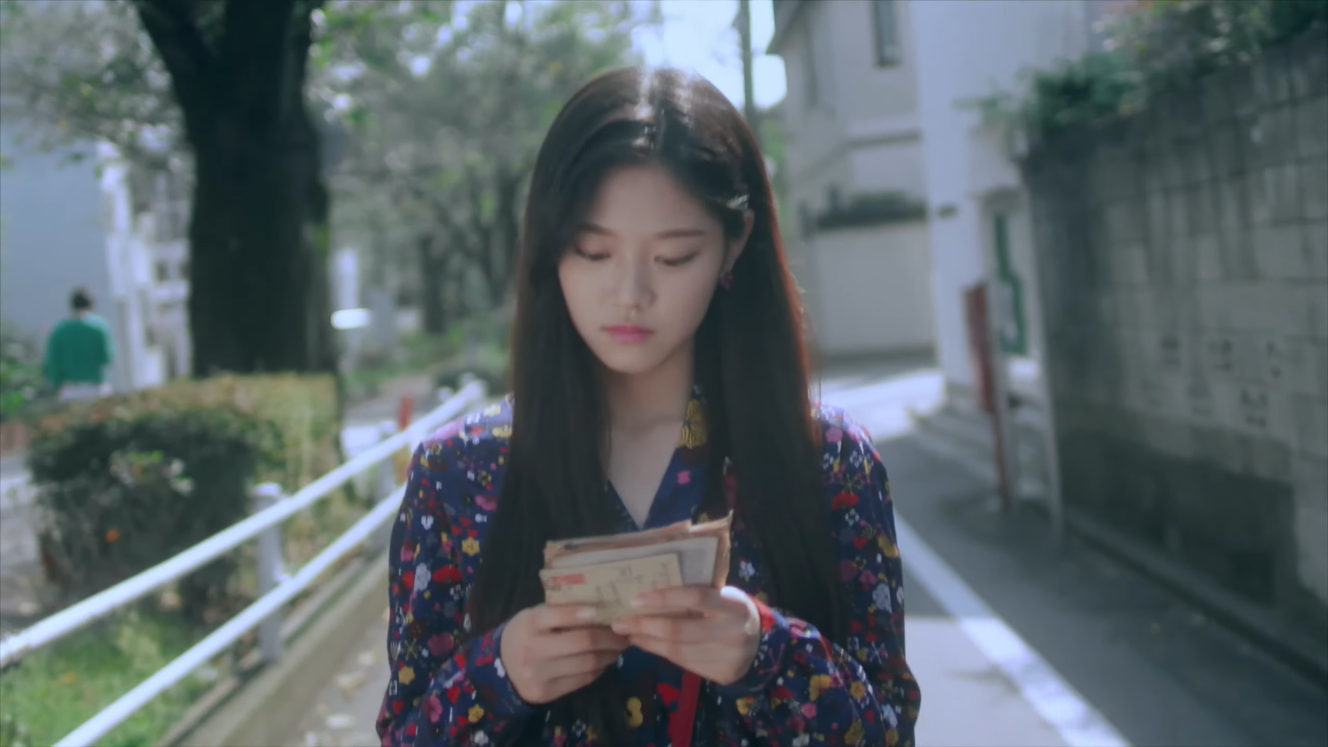 Hyunjin looking at the letters she's holding.